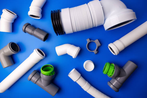pvc drainage pipes and fittings on blue background. top view